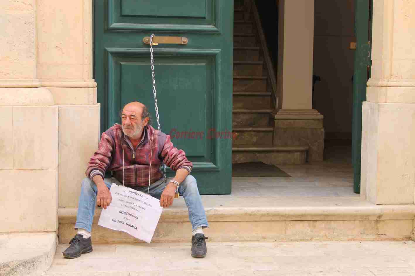 Stipendi in ritardo: dipendente comunale si incatena alla porta del Comune di Rosolini